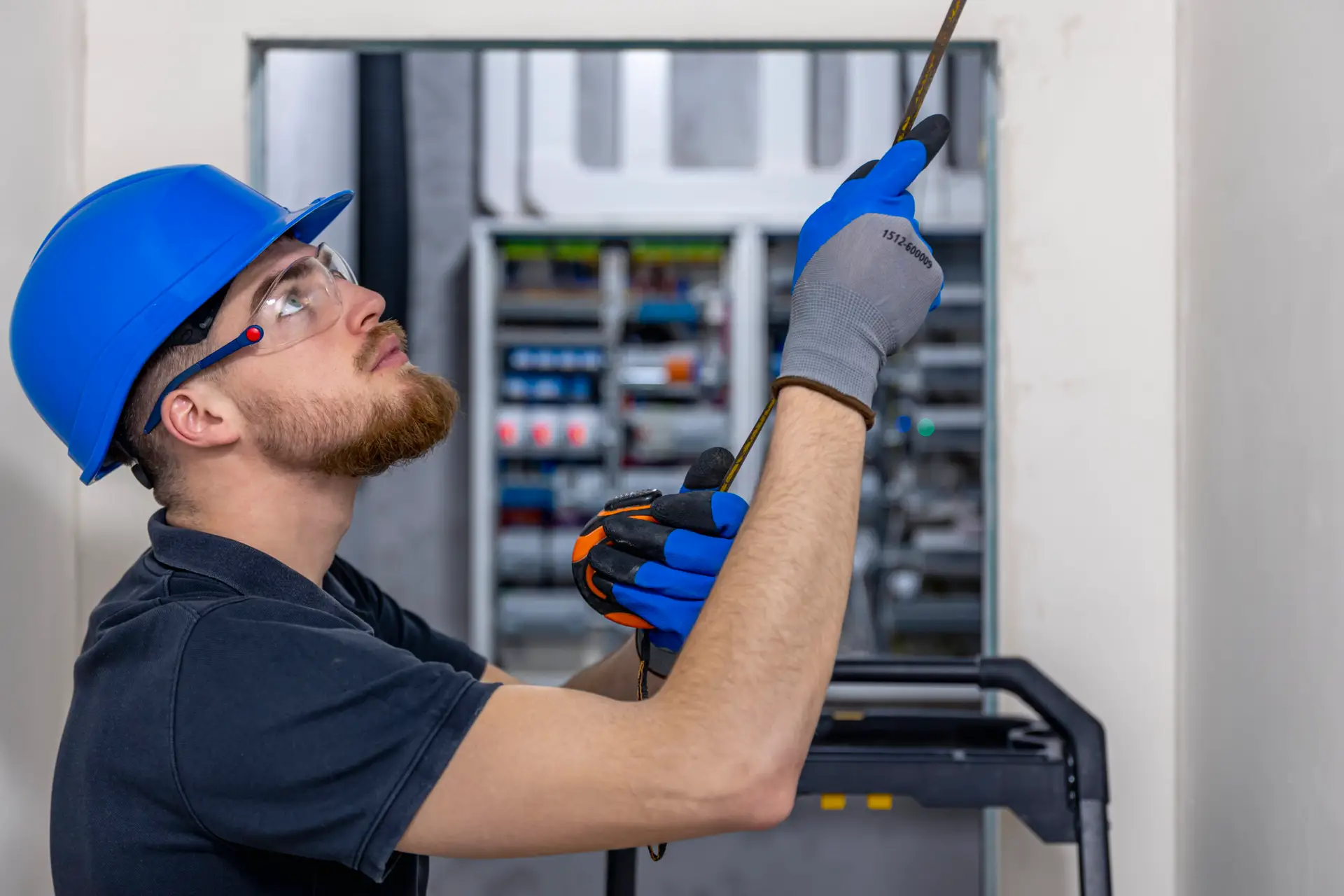 Eston Elevators Company electrician installing laying electrical cables on the ceiling inside the house.